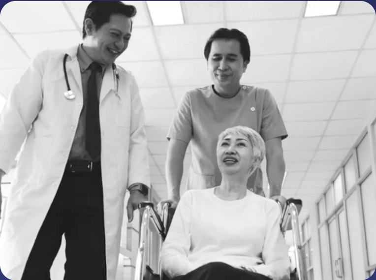 doctor and nurse escorting patient in wheelchair