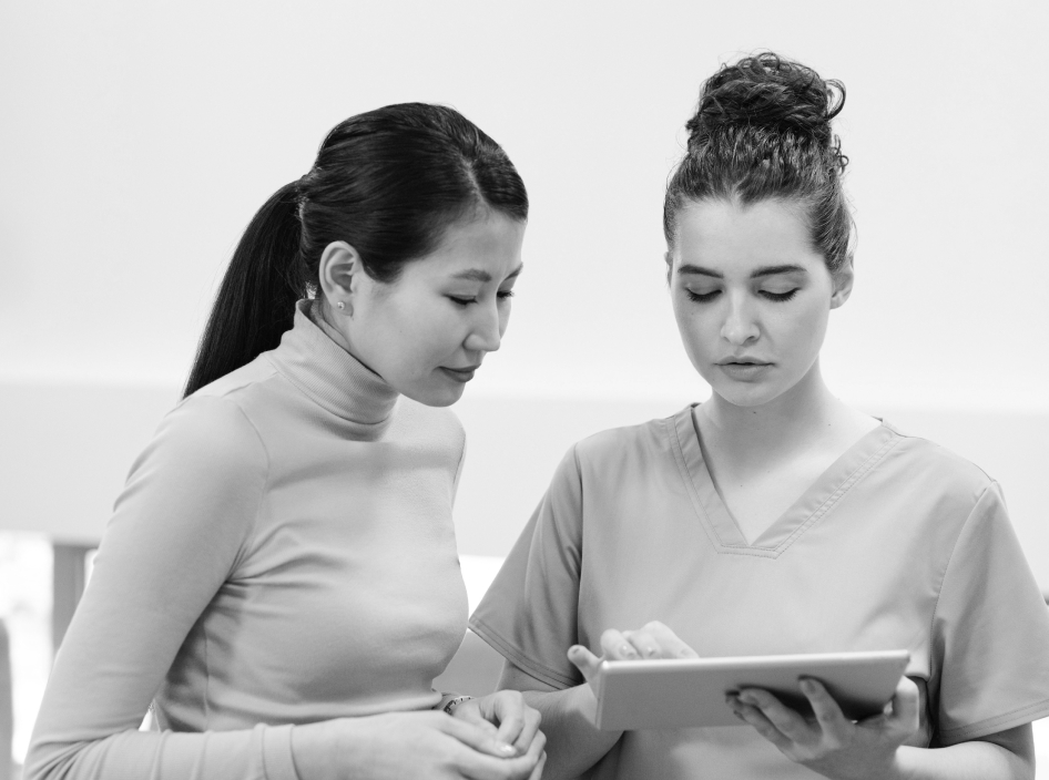 patient looking at tablet being held by nurse